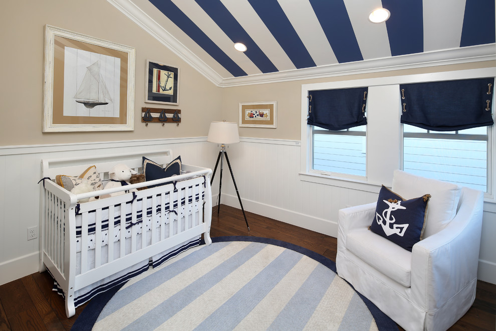 Réalisation d'une chambre de bébé neutre marine avec un mur beige et parquet foncé.