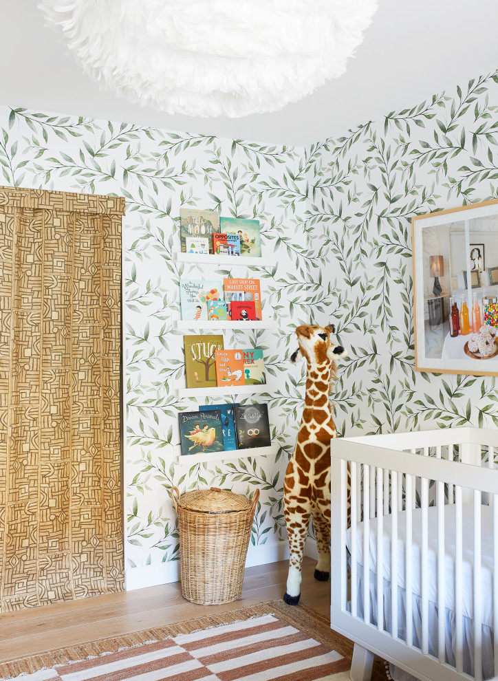 Ejemplo de habitación de bebé neutra bohemia con paredes multicolor, suelo de madera clara, suelo marrón y papel pintado