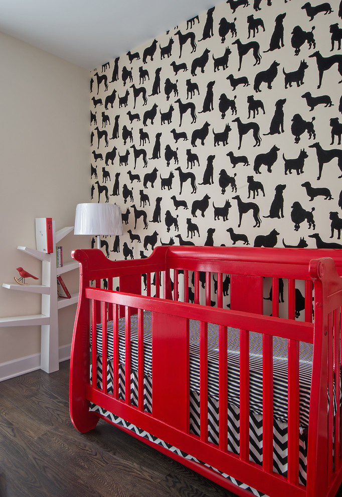 Cette image montre une chambre de bébé neutre design avec un mur multicolore et un sol en bois brun.
