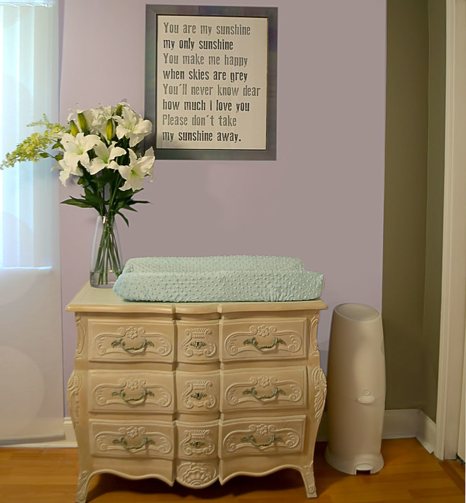 Exemple d'une chambre de bébé fille moderne de taille moyenne avec un mur violet et parquet clair.