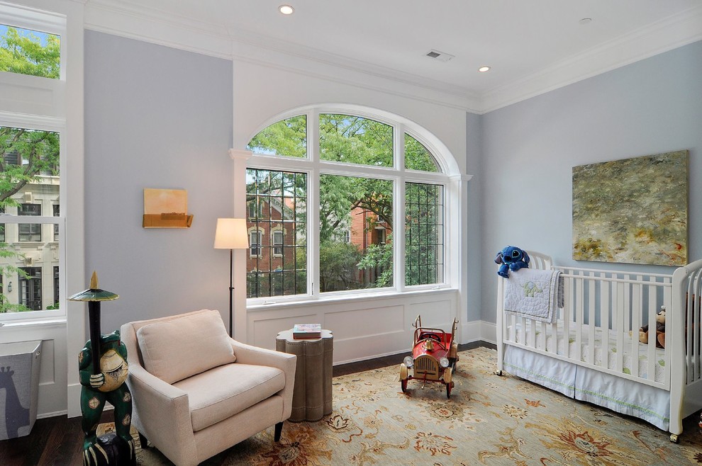 Cette photo montre une grande chambre de bébé garçon chic avec un mur bleu et parquet foncé.