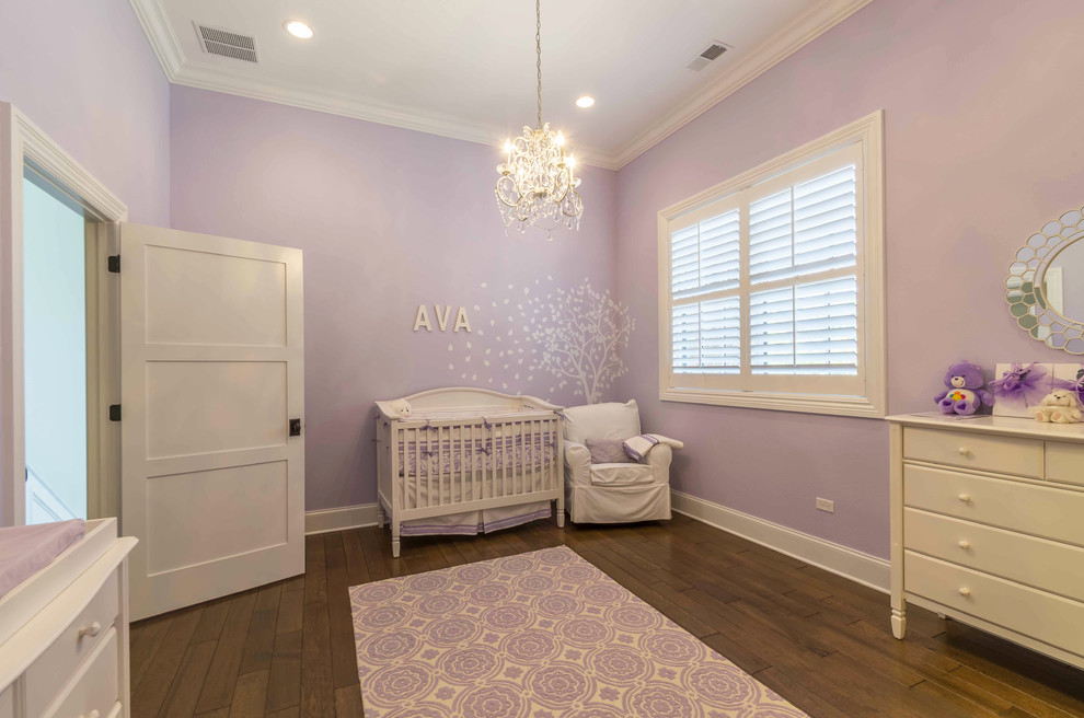 Ejemplo de habitación de bebé niña blanca clásica renovada de tamaño medio con paredes púrpuras, suelo de madera en tonos medios, suelo marrón, bandeja y papel pintado