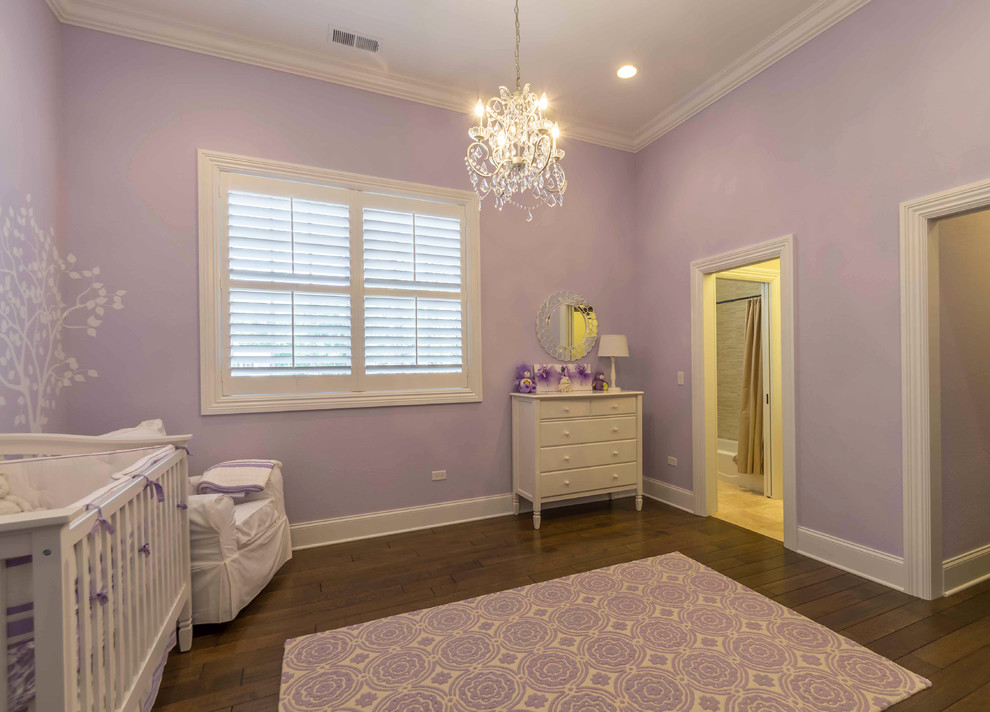 Diseño de habitación de bebé niña blanca clásica renovada de tamaño medio con paredes púrpuras, suelo de madera en tonos medios, suelo marrón, bandeja y papel pintado
