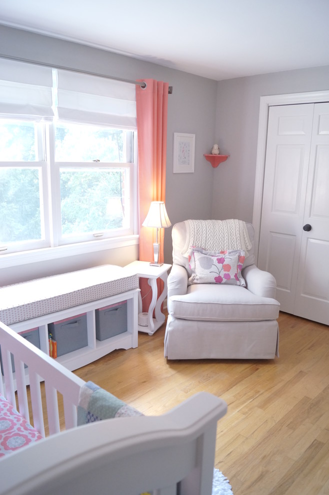 Design ideas for a medium sized classic nursery for girls in Other with grey walls and light hardwood flooring.