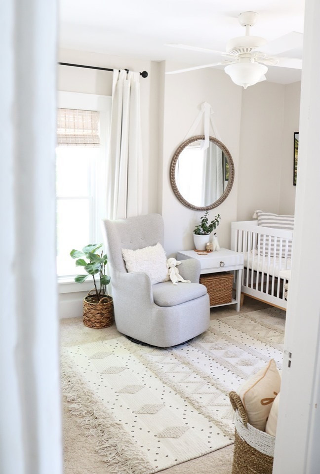 Cette image montre une petite chambre de bébé neutre nordique avec un mur gris, moquette et un sol beige.
