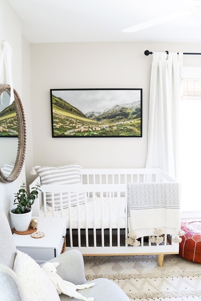 Diseño de habitación de bebé neutra escandinava pequeña con paredes grises y moqueta