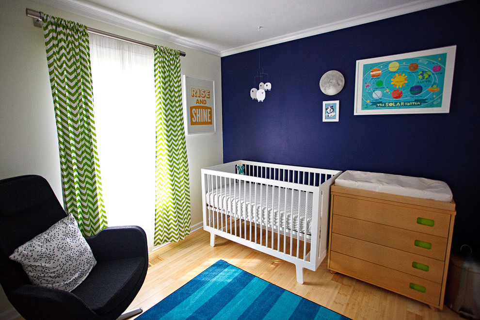 Diseño de habitación de bebé neutra moderna con suelo de bambú y paredes azules