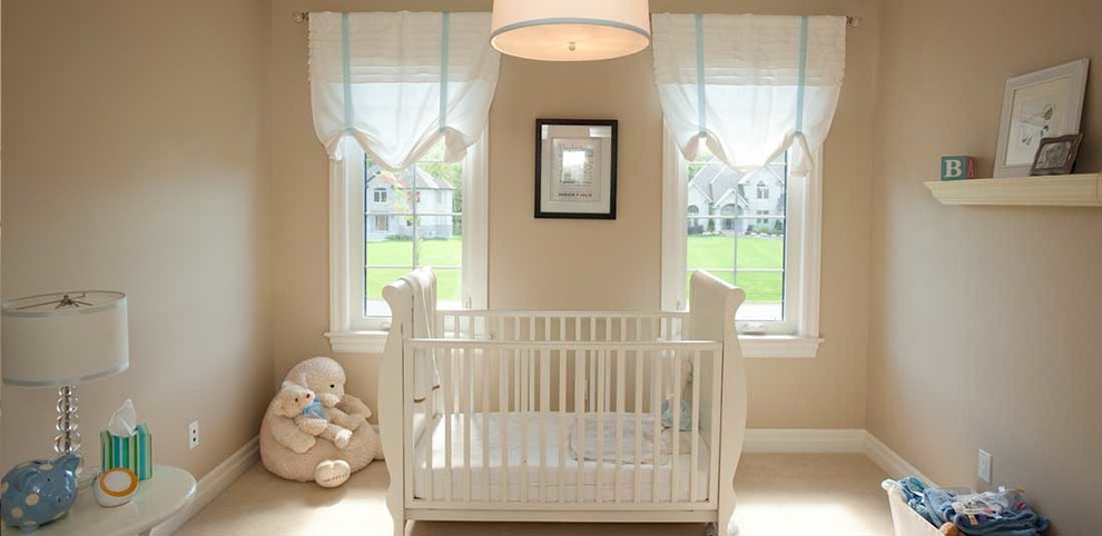 Immagine di una cameretta per neonato tropicale di medie dimensioni con pareti beige e moquette