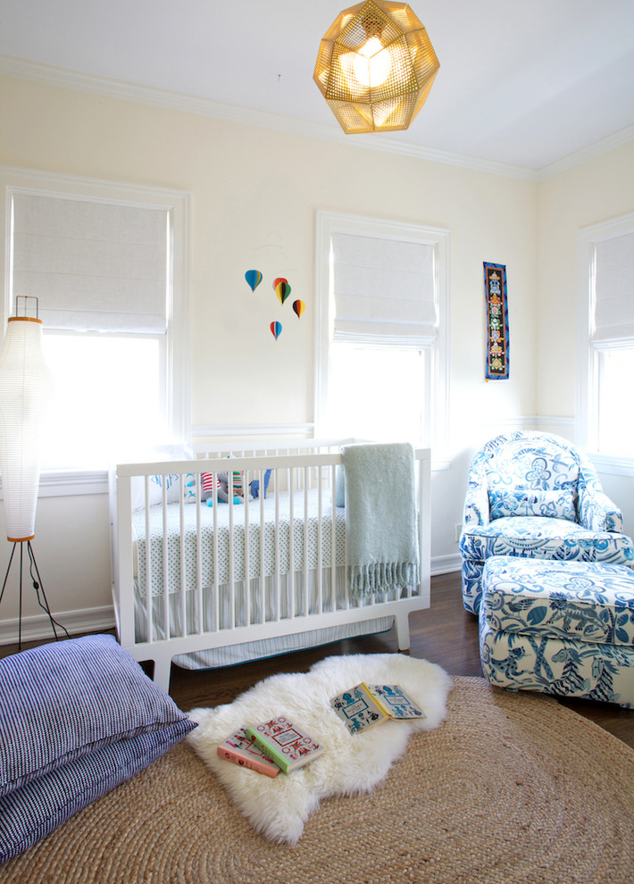 Ejemplo de habitación de bebé neutra clásica renovada de tamaño medio con paredes blancas y suelo de madera oscura