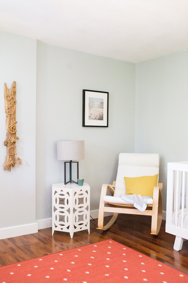 Small eclectic girl medium tone wood floor nursery photo in Boston with gray walls