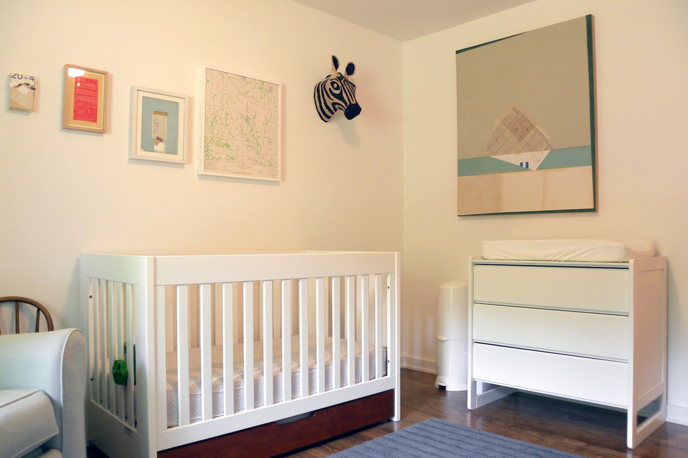 На фото: нейтральная комната для малыша в стиле ретро с белыми стенами и темным паркетным полом