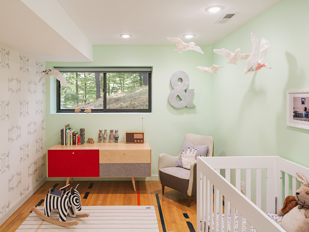 Neutrales Mid-Century Babyzimmer mit grüner Wandfarbe und braunem Holzboden in Philadelphia
