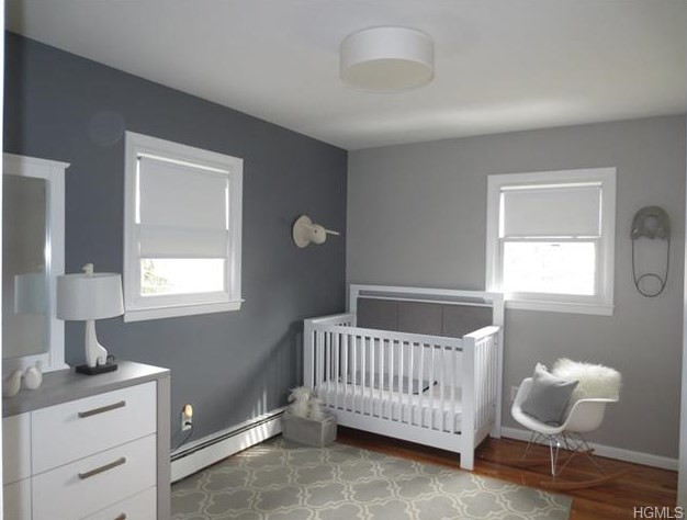 Réalisation d'une petite chambre de bébé neutre tradition avec un mur gris et parquet foncé.