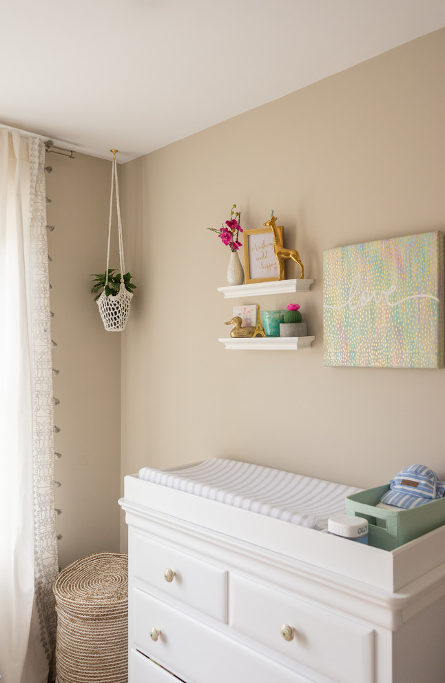 This is an example of a traditional gender neutral nursery in Boston with beige walls.