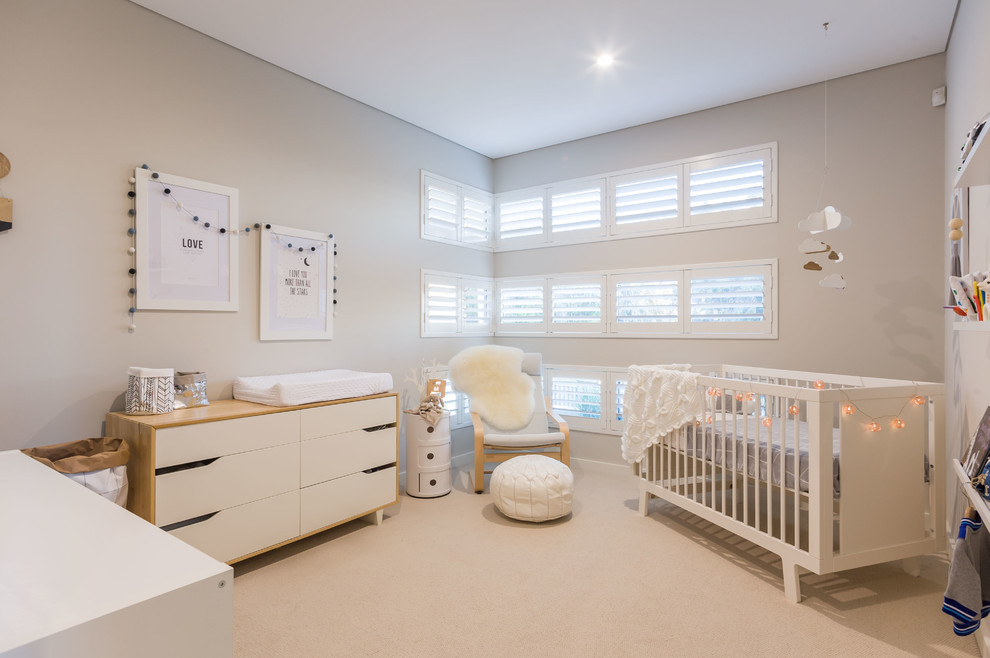 На фото: нейтральная комната для малыша в скандинавском стиле с серыми стенами, ковровым покрытием и бежевым полом