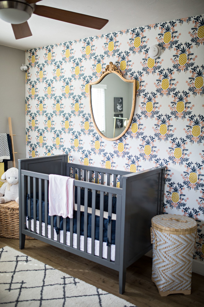 Foto de habitación de bebé niña moderna de tamaño medio con paredes grises, suelo laminado y suelo beige