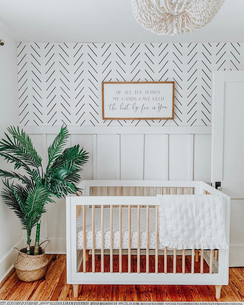 Inspiration pour une petite chambre de bébé garçon vintage avec un mur blanc, un sol en bois brun et un sol marron.