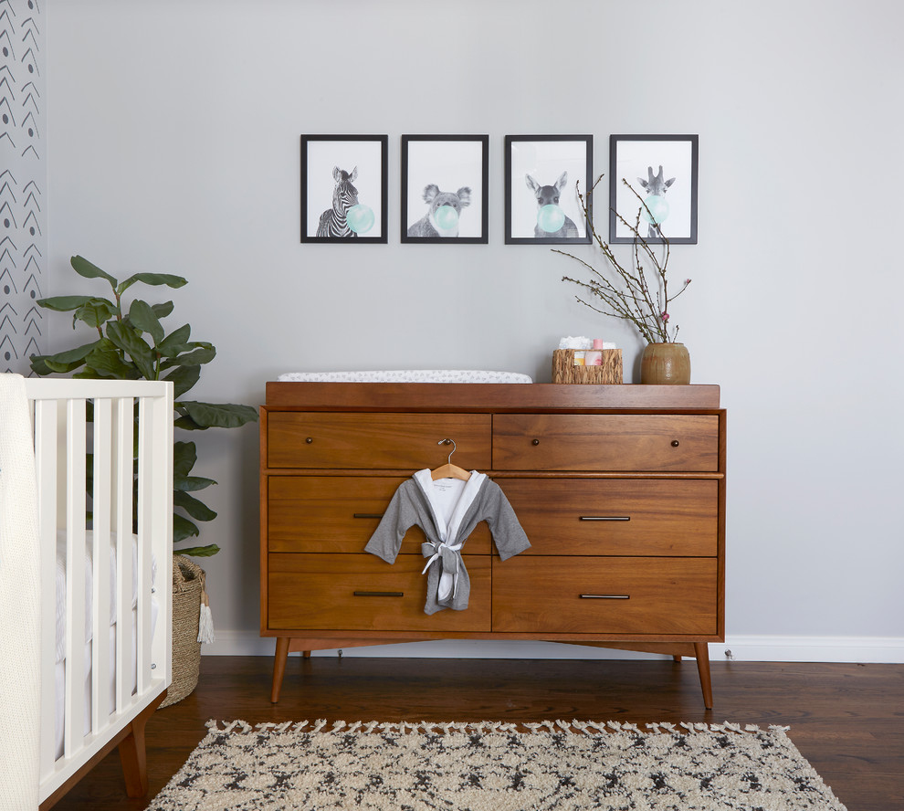 Modelo de habitación de bebé niña nórdica de tamaño medio con paredes grises, suelo de madera oscura y suelo marrón
