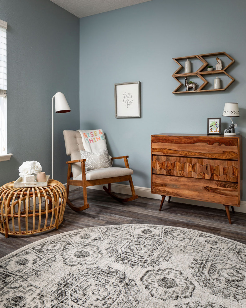Modelo de habitación de bebé neutra vintage pequeña con paredes azules, suelo vinílico y suelo gris