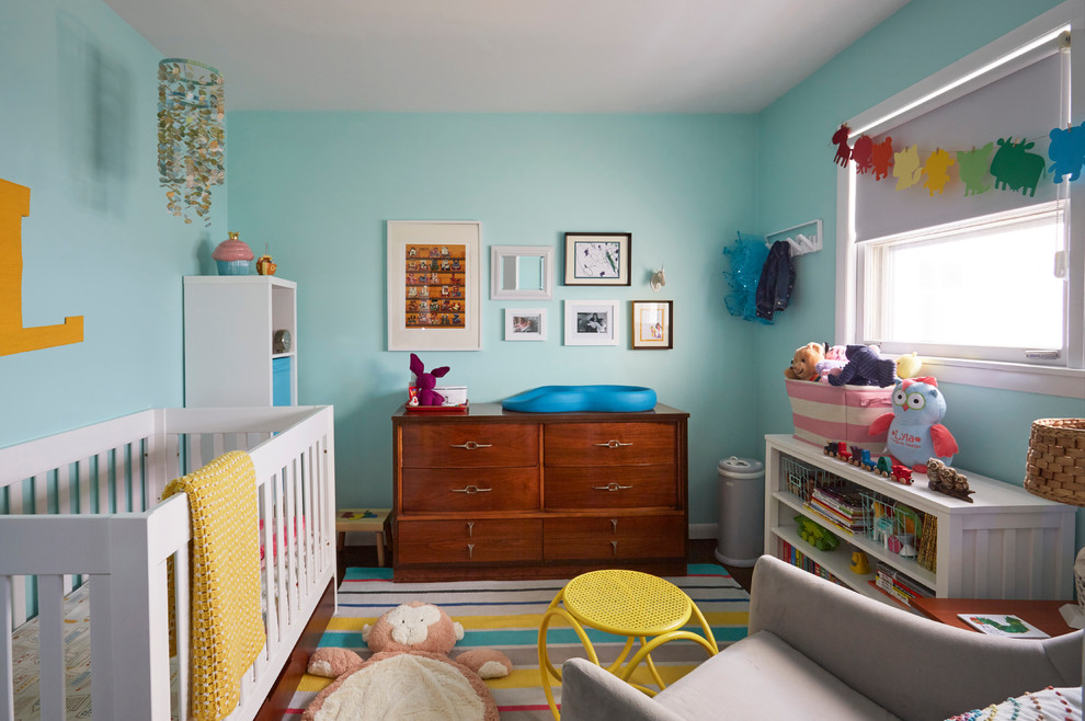 Exemple d'une petite chambre de bébé fille rétro avec un mur vert, parquet foncé et un sol marron.