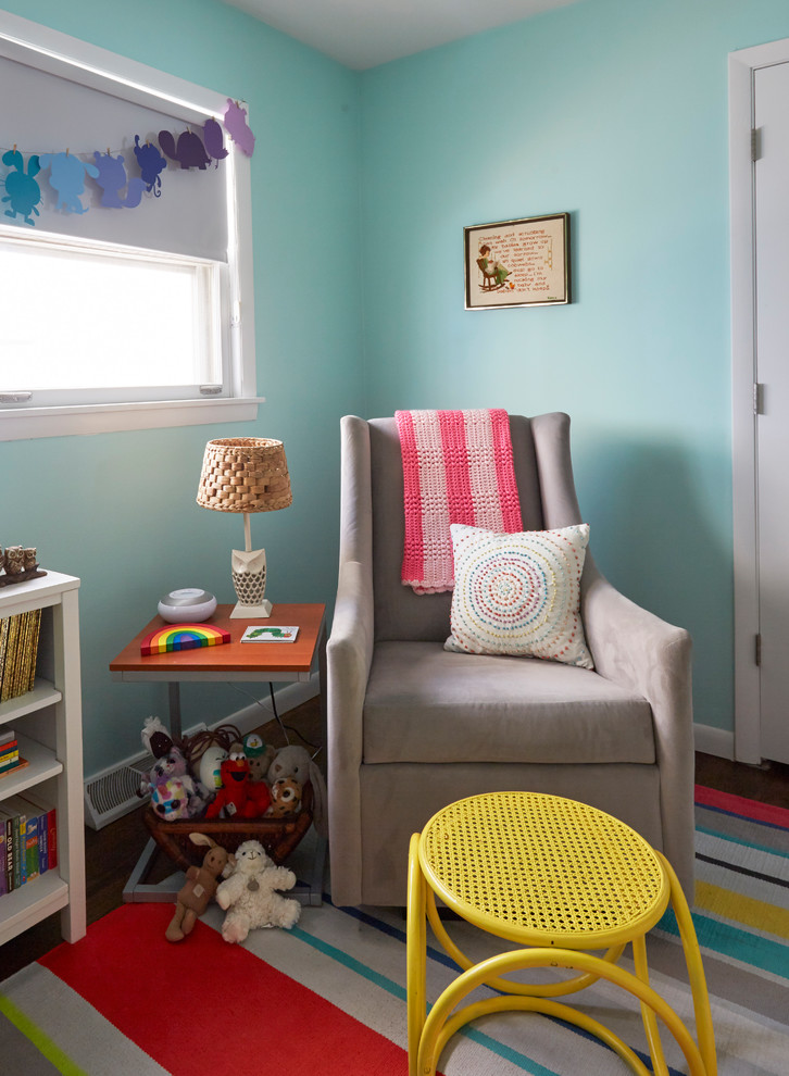 Cette photo montre une petite chambre de bébé fille rétro avec un mur vert, parquet foncé et un sol marron.