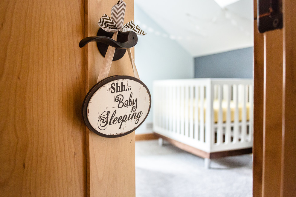 Cette photo montre une grande chambre de bébé garçon moderne avec un mur bleu, moquette et un sol blanc.