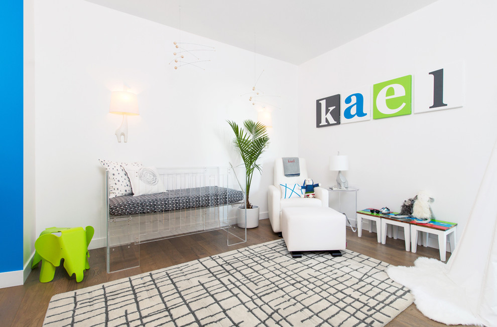 Foto de habitación de bebé niño moderna de tamaño medio con paredes blancas y suelo de madera en tonos medios