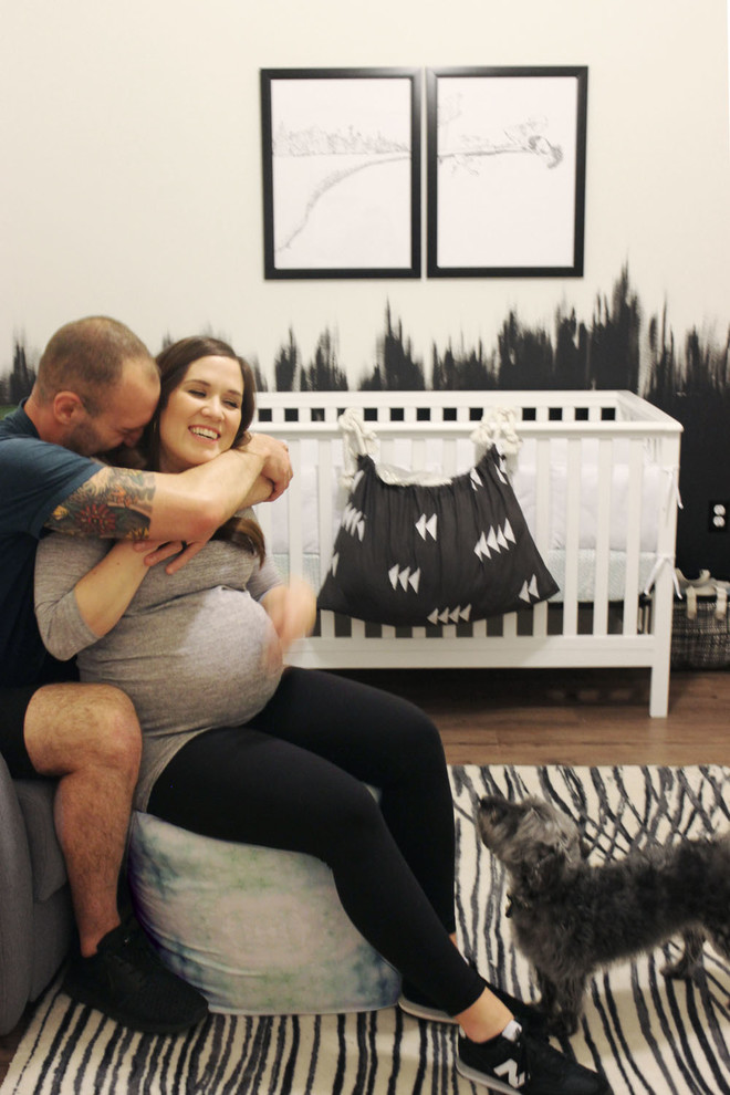 Aménagement d'une chambre de bébé garçon moderne de taille moyenne avec un mur blanc et un sol en bois brun.