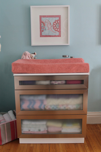 This is an example of a medium sized eclectic nursery for girls in Toronto with blue walls and medium hardwood flooring.