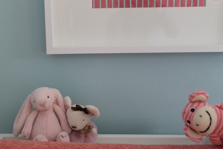 Idées déco pour une chambre de bébé fille éclectique de taille moyenne avec un mur bleu et un sol en bois brun.