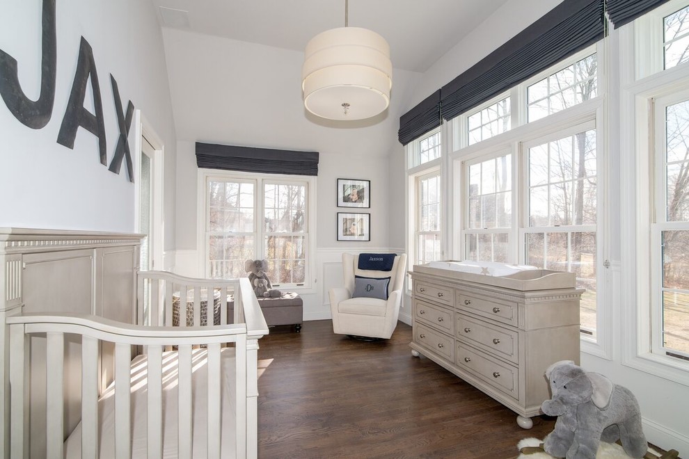 Example of a large transitional gender-neutral dark wood floor nursery design in New York with white walls