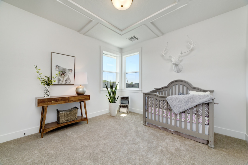 Modelo de habitación de bebé neutra campestre de tamaño medio con paredes blancas, moqueta y suelo beige