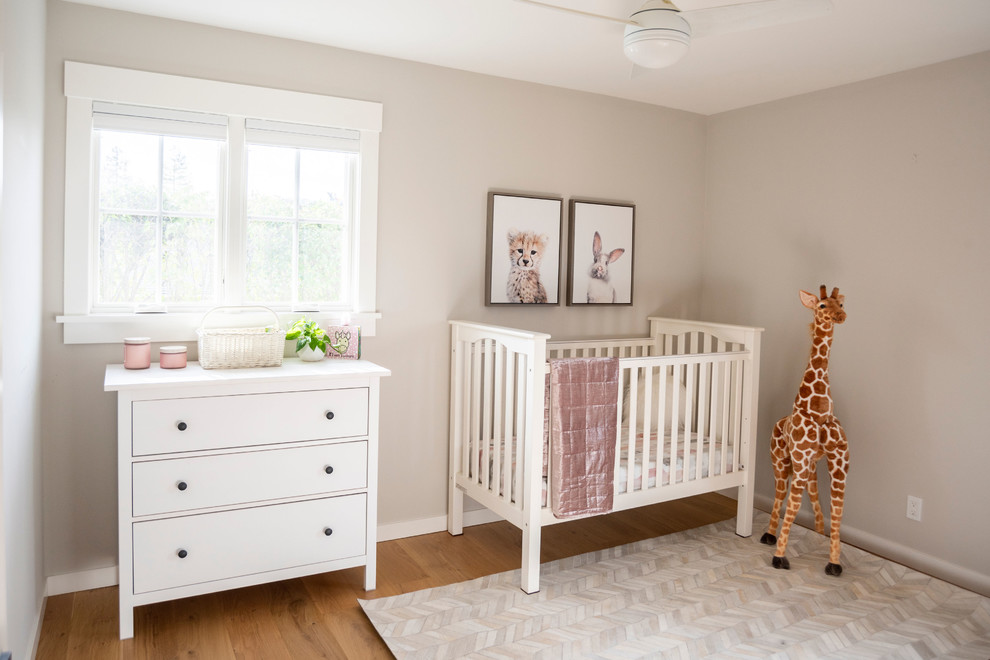 Modelo de habitación de bebé niña de estilo de casa de campo pequeña con paredes beige y suelo de madera clara