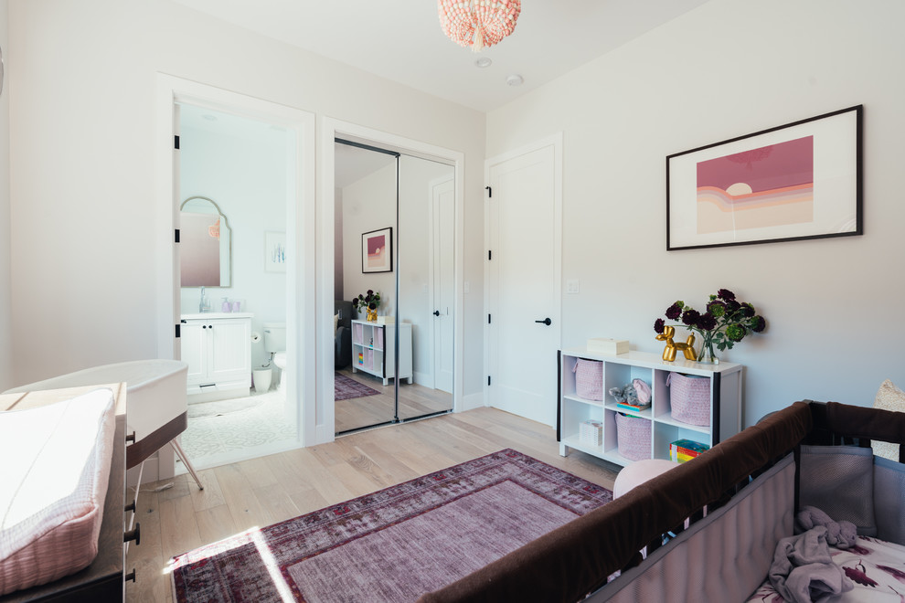 Ispirazione per una cameretta per neonata country di medie dimensioni con pareti viola e parquet chiaro