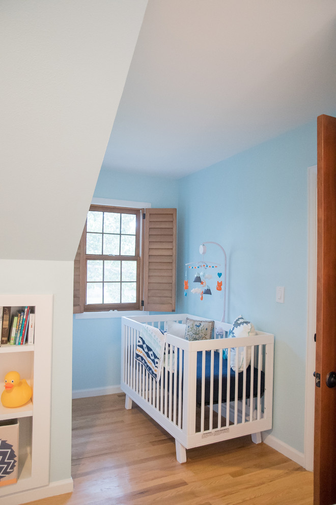 Inspiration pour une chambre de bébé garçon design avec un mur bleu, un sol en bois brun et un sol marron.