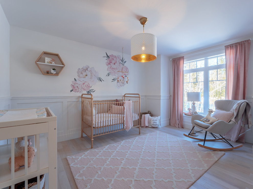 Foto de habitación de bebé niña tradicional renovada grande con paredes blancas, suelo de madera clara y suelo beige
