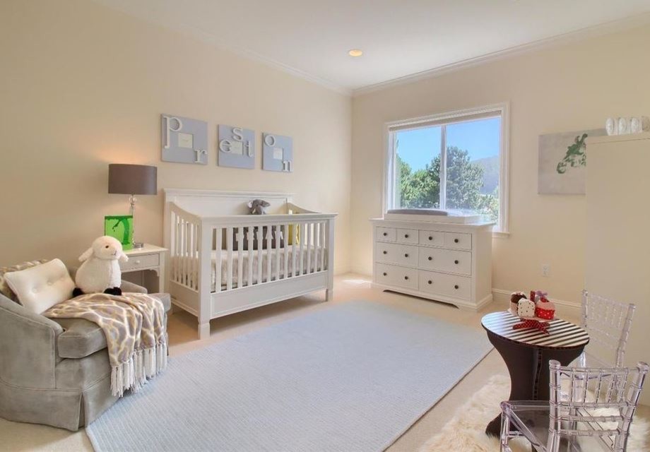 This is an example of a medium sized classic gender neutral nursery in San Francisco with beige walls, carpet and brown floors.