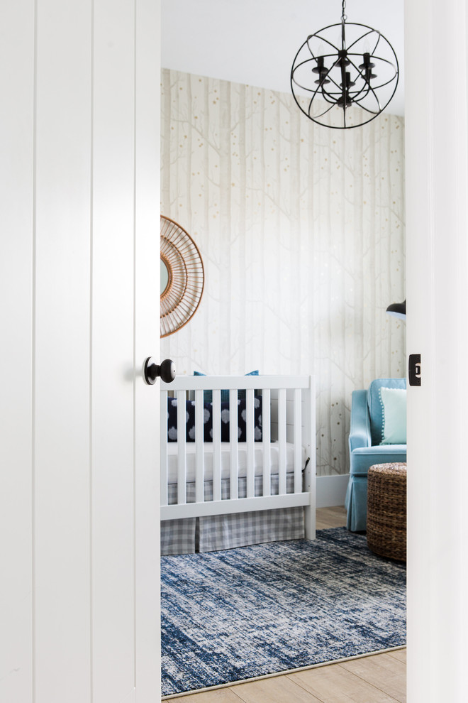 Imagen de habitación de bebé niño tradicional renovada pequeña con paredes beige y suelo de madera clara