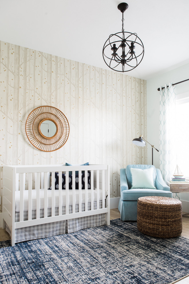 Modelo de habitación de bebé niño tradicional renovada pequeña con paredes beige y suelo de madera clara