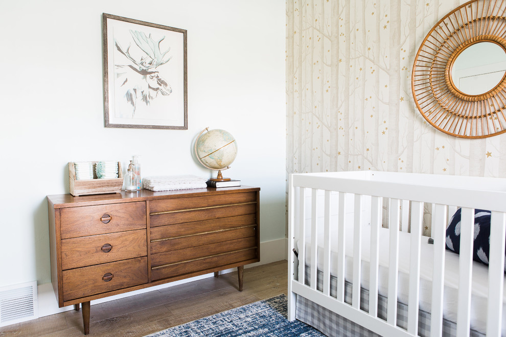 Réalisation d'une petite chambre de bébé garçon tradition avec un mur beige et parquet clair.
