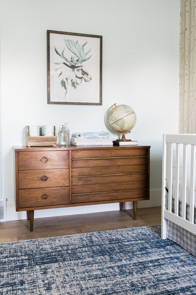 Immagine di una piccola cameretta per neonato tradizionale con pareti beige e parquet chiaro