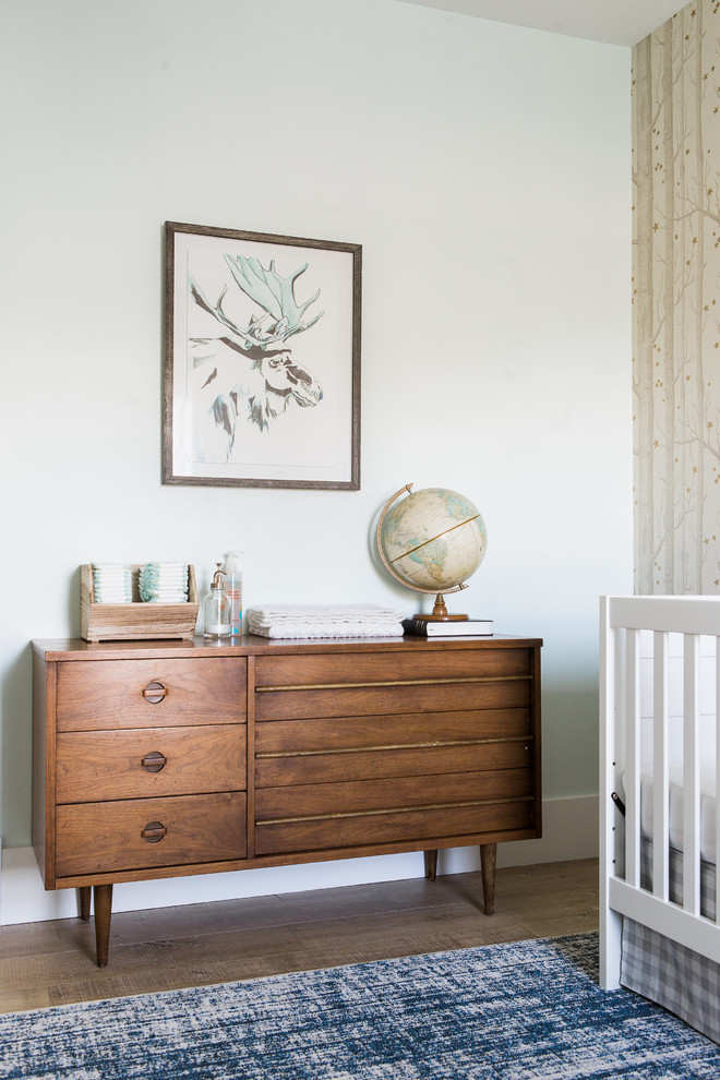 Modelo de habitación de bebé niño tradicional renovada pequeña con paredes beige y suelo de madera clara