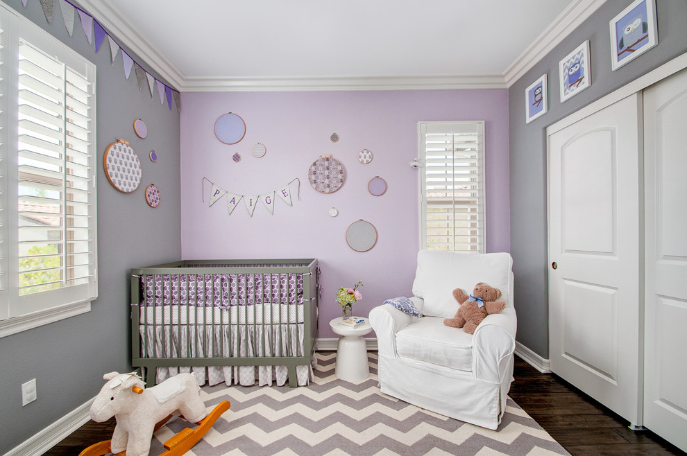 Example of a mid-sized transitional girl dark wood floor nursery design in San Diego with purple walls
