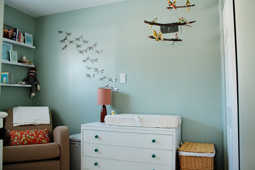 Cette photo montre une chambre de bébé neutre tendance avec un mur bleu.