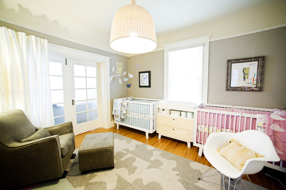 Idées déco pour une chambre de bébé neutre éclectique de taille moyenne avec un mur gris et un sol en bois brun.