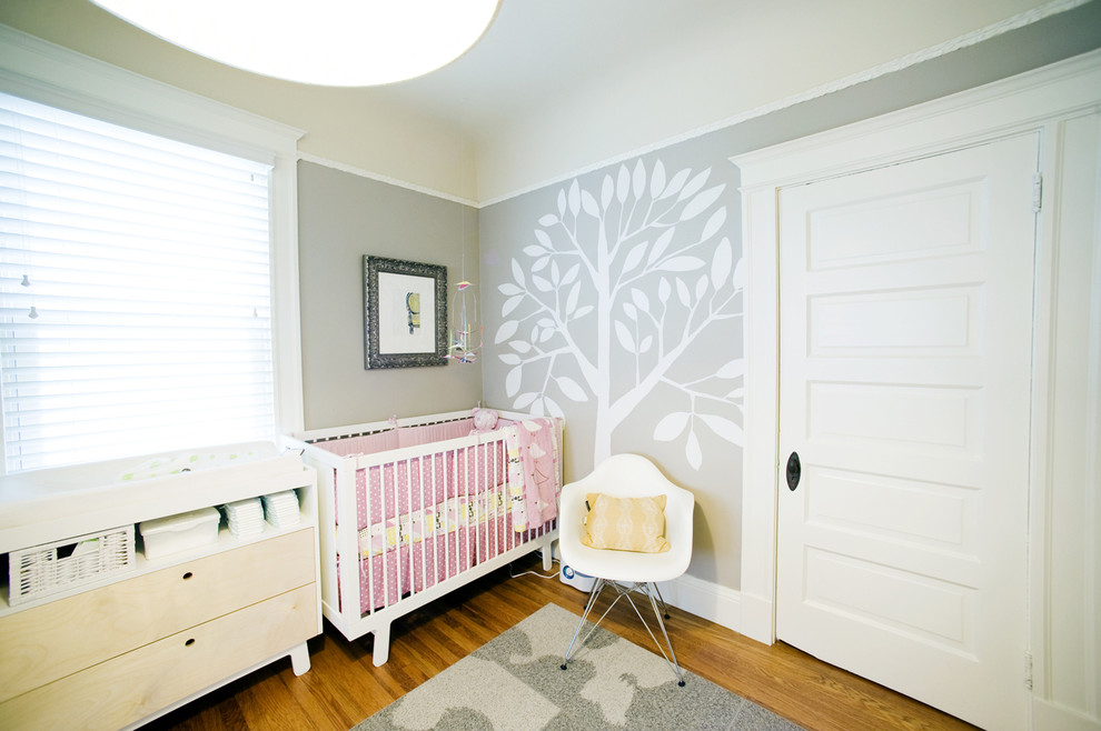 Mittelgroßes Stilmix Babyzimmer mit grauer Wandfarbe und braunem Holzboden in San Francisco