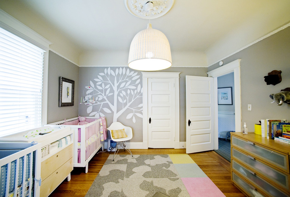 サンフランシスコにある中くらいなトランジショナルスタイルのおしゃれな赤ちゃん部屋 (グレーの壁、無垢フローリング、女の子用) の写真