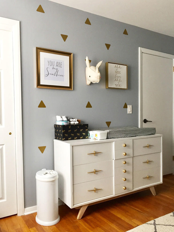 Kleines Skandinavisches Babyzimmer mit grauer Wandfarbe und braunem Holzboden in New York