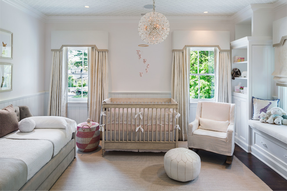 Inspiration for a medium sized classic nursery for girls in New York with pink walls, dark hardwood flooring, brown floors and feature lighting.