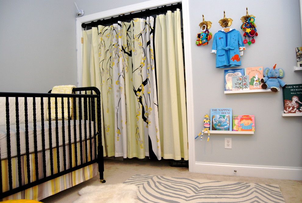 Cette image montre une chambre de bébé neutre design avec un mur gris.